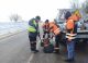 Echipe de drumari aplicând asfalt la rece pentru plombarea gropilor pe drumurile naționale